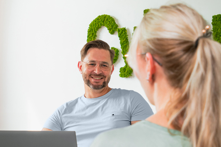Friendly man with glasses advises a woman sitting opposite him
